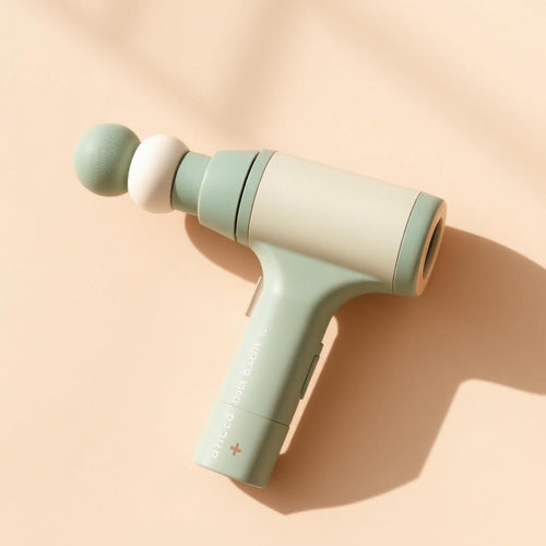 Massagepistole in Salbeigrün und Creme